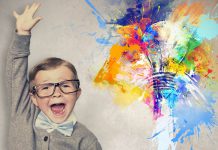 خلاقیت در کودکان- پسری عینکی با کت و پاپیون متعجب در طرف چپ تصویر و سمت راست لامپی که رنگهای مختلف در اطرافش پخش شده اند