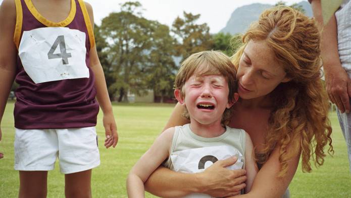 پسری در آغوش مادر که در مسابقه باخته است و گریه می کند. لذا فضای خوبی برای آموزش شکست خوردن به کودک فراهم آمده است